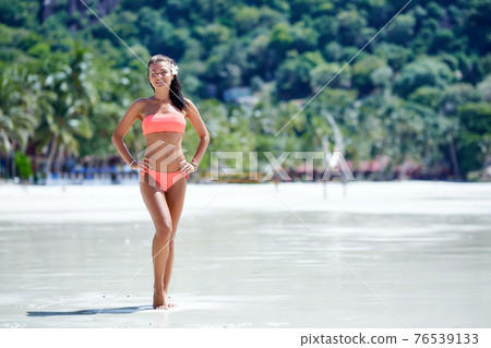 Sexy girl in red swimsuit posing at the tropical beach Sexy girl in red swimsuit posing at the tropical beach 76539133