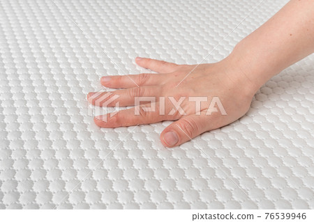 Woman is choosing new mattress for good sleeping 76539946