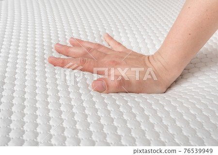 Woman is choosing new mattress for good sleeping 76539949