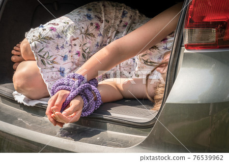 Woman with tied hands inside car trunk - kidnapping Woman with tied hands inside car trunk - kidnapping 76539962