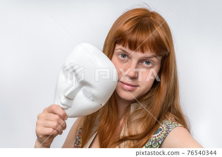 Mysterious woman cover her face behind anonymous mask 76540344