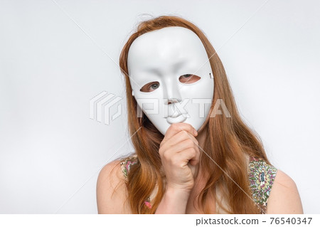 Mysterious woman cover her face behind anonymous mask Mysterious woman cover her face behind anonymous mask 76540347