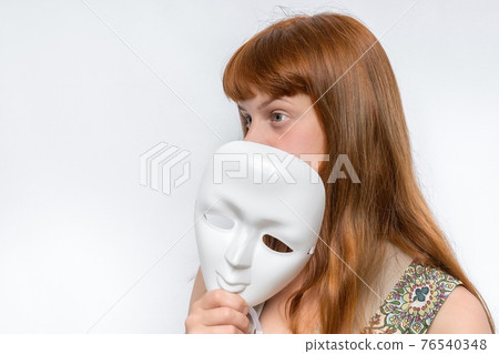 Mysterious woman cover her face behind anonymous mask 76540348