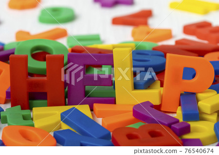 Plastic colored letters spelling word HELP Plastic colored letters spelling word HELP 76540674