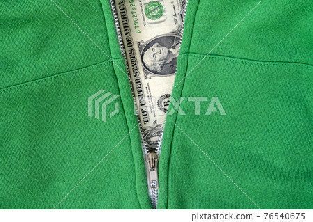 Close-up view of green sweatshirt with zipper and one dollar Close-up view of green sweatshirt with zipper and one dollar 76540675