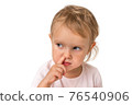 Baby girl is picking her nose with finger inside 76540906