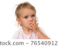 Baby girl is picking her nose with finger inside 76540912