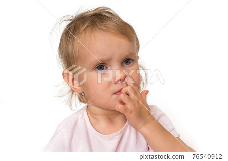 Baby girl is picking her nose with finger inside 76540912