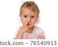 Baby girl is picking her nose with finger inside 76540913