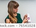 Woman holding a shirt with lipstick of her unfaithful husband 76541028