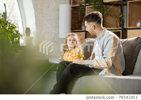 Happy father and little cute daughter at home. Family time, togehterness, parenting and happy childhood concept. Weekend with sincere emotions. Happy father and little cute daughter at home. Family time, togehterness, parenting and happy childhood concept. Weekend with sincere emotions. 76541851