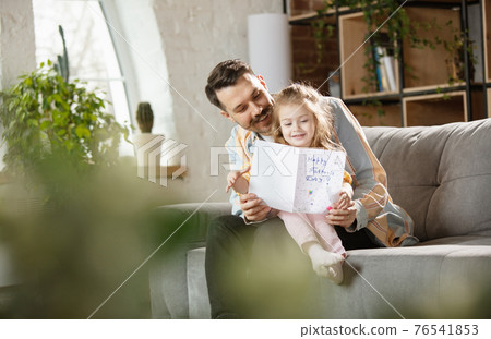 Happy father and little cute daughter at home. Family time, togehterness, parenting and happy childhood concept. Weekend with sincere emotions. Happy father and little cute daughter at home. Family time, togehterness, parenting and happy childhood concept. Weekend with sincere emotions. 76541853