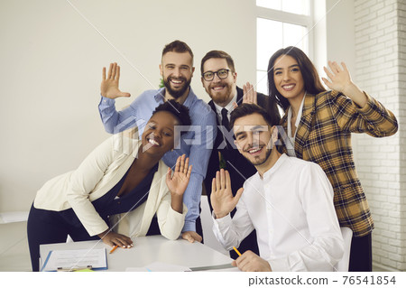 Group portrait of happy young business people waving hands at camera and smiling Group portrait of happy young business people waving hands at camera and smiling 76541854