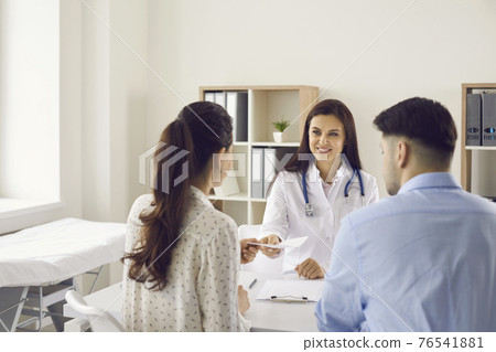 Doctor gives a referral for a medical examination of a couple sitting with their backs to the camera Doctor gives a referral for a medical examination of a couple sitting with their backs to the camera 76541881