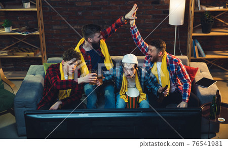 Group of friends watching TV, sport match together. Emotional fans cheering for favourite team, watching on exciting game. Concept of friendship, leisure activity, emotions 76541981