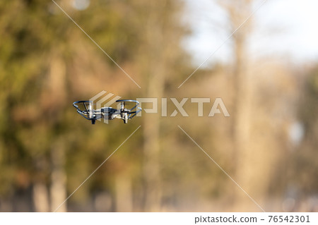 Small drone with little camera flying in the park 76542301
