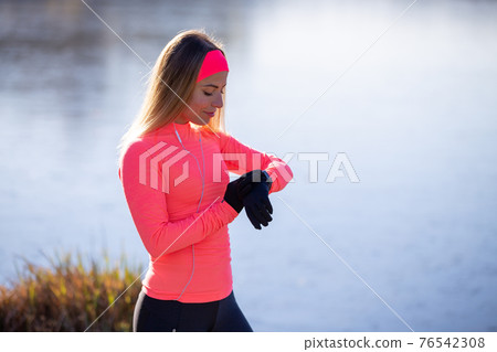 Sporty girl checking out her fitness tracker watch 76542308