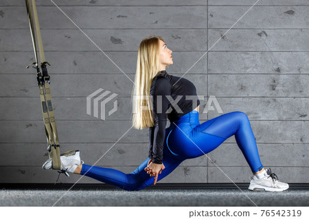 Fitness young blonde woman doing stretching in gym 76542319