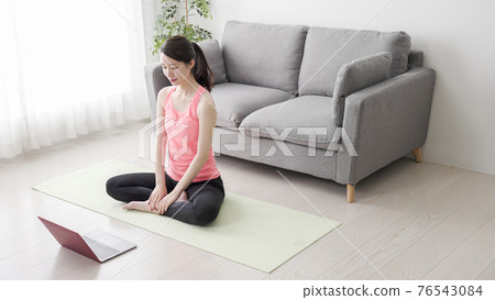 Young women taking yoga stretching classes online Young women taking yoga stretching classes online 76543084