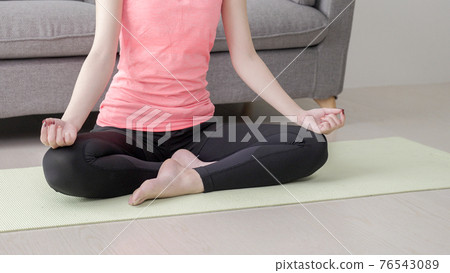 A woman doing yoga at home A woman doing yoga at home 76543089