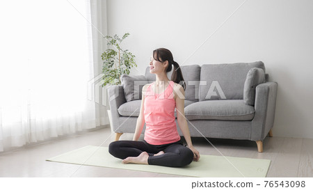 Young woman stretching at home Young woman stretching at home 76543098
