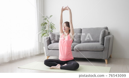 Young woman stretching at home Young woman stretching at home 76543099