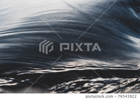 Fast flowing cold water mountain stream, flowing stream stream with flat smooth surface, nature outdoors, fresh stream dark blue 76543922