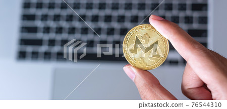 businessman hand hold golden Monero (XMR) cryptocurrency coin over keyboard laptop, Monero coin. Crypto is Digital Money within the blockchain network businessman hand hold golden Monero (XMR) cryptocurrency coin over keyboard laptop, Monero coin. Crypto is Digital Money within the blockchain network 76544310