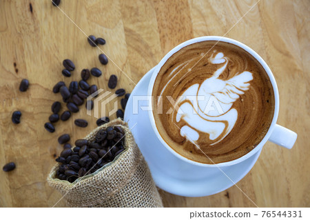 Art Coffee in White Cup on wood table in coffee shop. 76544331