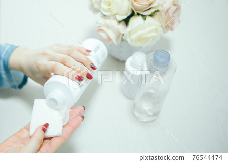 Women's hands doing skin care 76544474