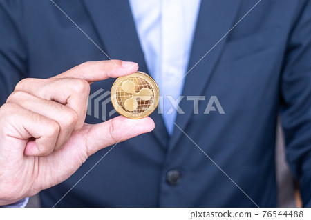 Businessman hand holding golden Ripple (XRP) cryptocurrency coin, Crypto is Digital Money within the blockchain network, is exchanged using technology and online internet exchange. Financial concept Businessman hand holding golden Ripple (XRP) cryptocurrency coin, Crypto is Digital Money within the blockchain network, is exchanged using technology and online internet exchange. Financial concept 76544488