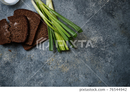 Bread with salt, green onions with water droplets Bread with salt, green onions with water droplets 76544942