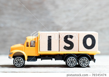 Truck hold letter block in word ISO on wood background 76545474