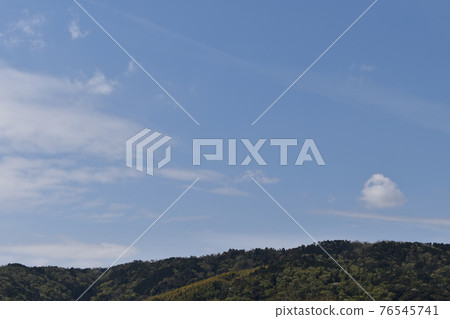 A cotton cloud floating on the ridge and a streak cloud going through the blue sky 76545741
