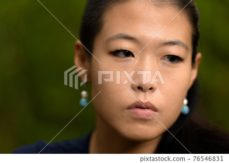 Close-up portrait of beautiful rebel Asian woman face looking serious while thinking outdoors Close-up portrait of beautiful rebel Asian woman face looking serious while thinking outdoors 76546831
