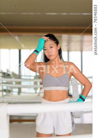 Asian woman kick boxer ready for exercise at gym boxing ring 76546883
