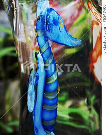 Blue seahorse. A fairytale sea world in crystal glass. Glass paperweight on a director's office desk Blue seahorse. A fairytale sea world in crystal glass. Glass paperweight on a director's office desk 76547406