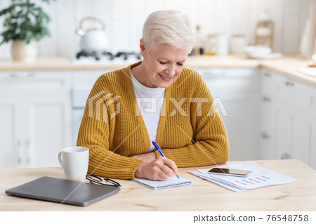 Positive elderly lady freelancer working from home or studying 76548758