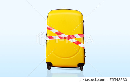 Colorful baggage wrapped in red and white barrier tape 76548880