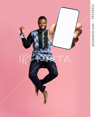 Check this out, cellphone display mockup. Excited black man showing smartphone with empty screen on pink background 76549351