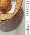 Sunny Breadbasket with long shadow on white wooden table top view. Closeup Bun in basket modern banner for snack food decorative design with copy space. Bright Corner bakery flat lay vertical concept 76550016