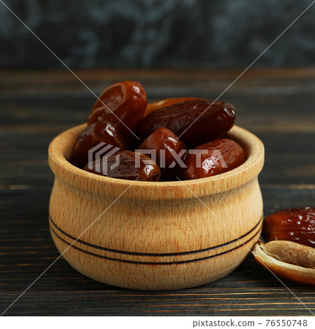 Bowl with dried dates on wooden table Bowl with dried dates on wooden table 76550748