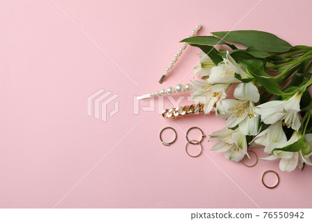 Jewelry and flowers on pink background, space for text Jewelry and flowers on pink background, space for text 76550942