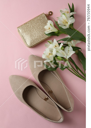 Womens shoes, cosmetic bag and flowers on pink background Womens shoes, cosmetic bag and flowers on pink background 76550944