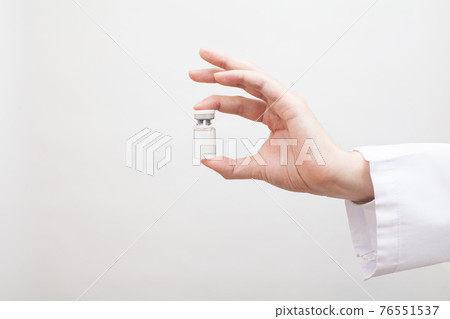 Vaccine bottles held by doctors and researchers 76551537