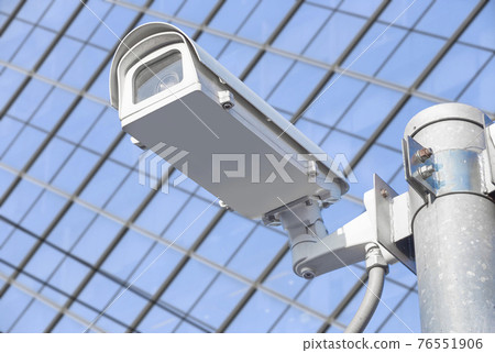 CCTV installed on the pole in front of the building windows. CCTV installed on the pole in front of the building windows. 76551906