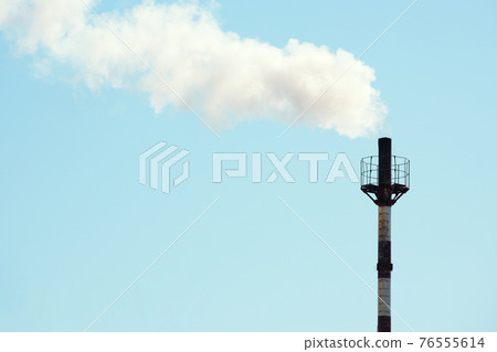 Smoke is coming from the gas boiler room pipe against the blue sky. 76555614