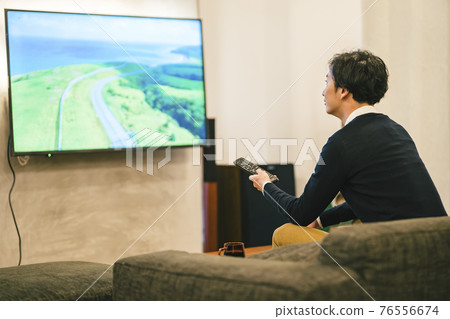 A man watching TV in a home theater A man watching TV in a home theater 76556674