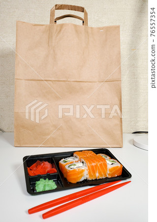 Japanese sushi roll for dinner on an isolated white background. The concept of the delivery of Japanese dishes 76557354