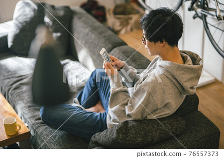 A man looking at Su Maho on the sofa A man looking at Su Maho on the sofa 76557373